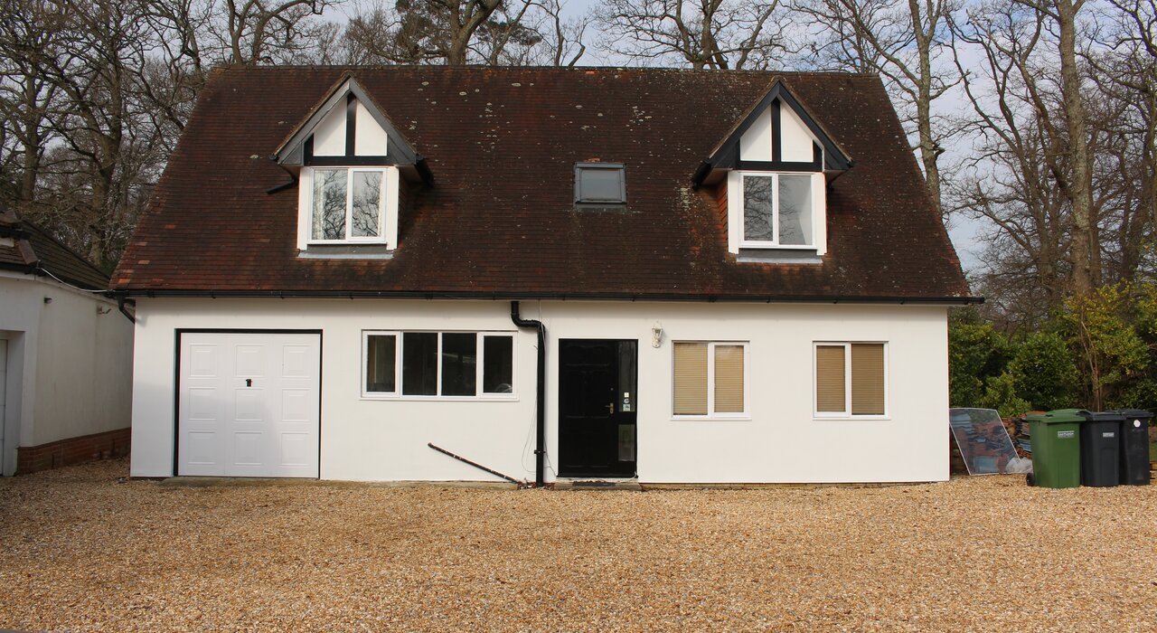 Detached house with newly rendered exterior following the installation of external wall insulation, improving thermal performance and updating the property's appearance