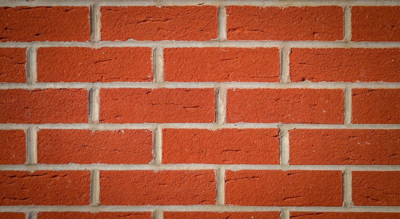 Close-up of red brick wall, a common substrate for external wall insulation systems requiring surface preparation before insulation boards are applied