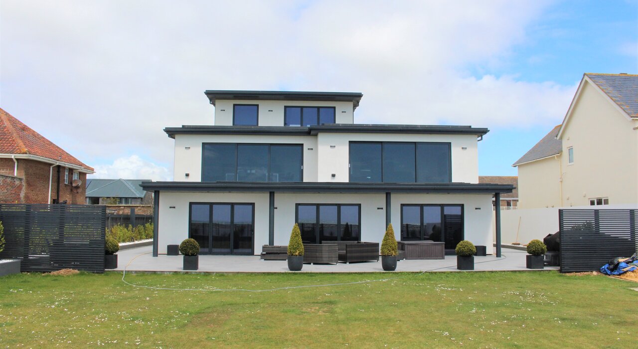 Modern three-storey home with a smooth rendered finish, likely applied over external wall insulation to enhance thermal performance, improve energy efficiency, and create a sleek contemporary look