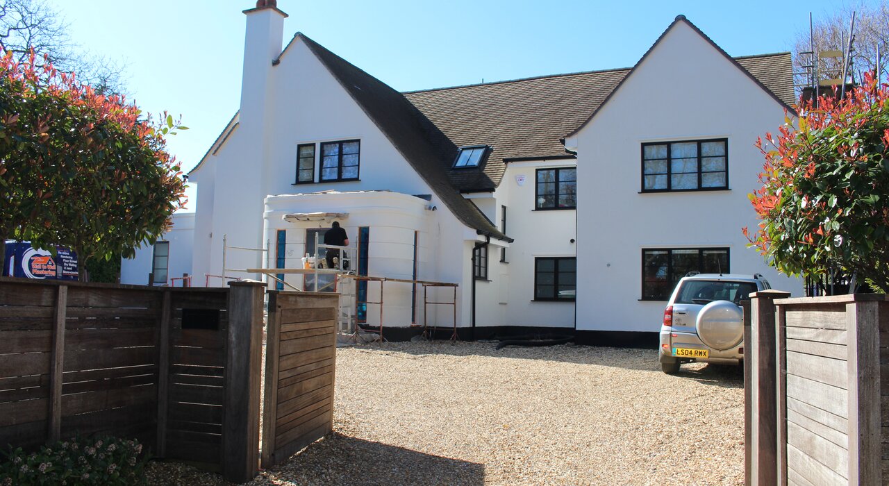 This image shows a large detached house with a clean, bright finish achieved using external wall insulation (EWI). The insulation helps boost energy efficiency, reduce heating bills, and gives the home a modern, smooth appearance.