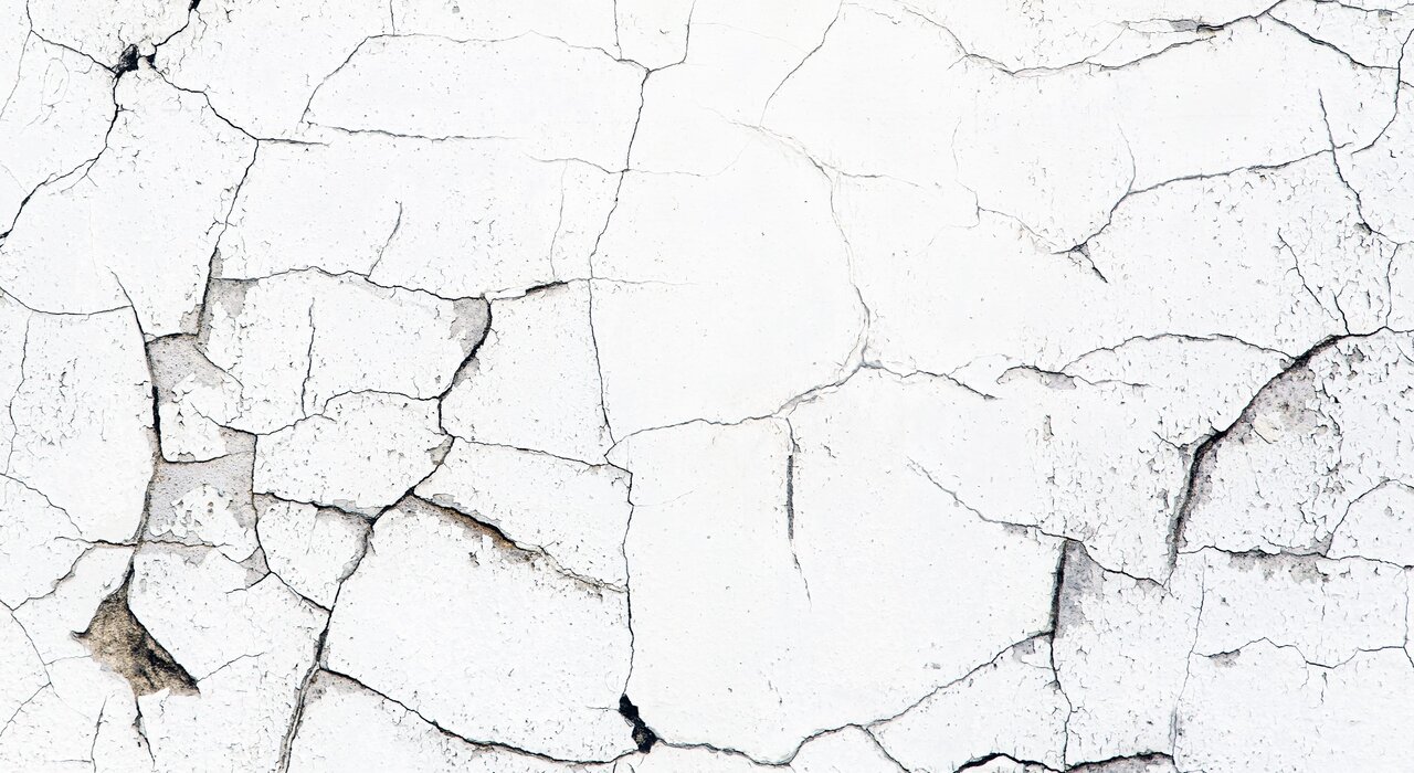 Close-up of a cracked and deteriorating wall surface, showing signs of ageing, poor insulation, and failing render. EWI Store offers high-quality external wall insulation systems and professional render solutions to prevent such damage and enhance the durability and appearance of façades.