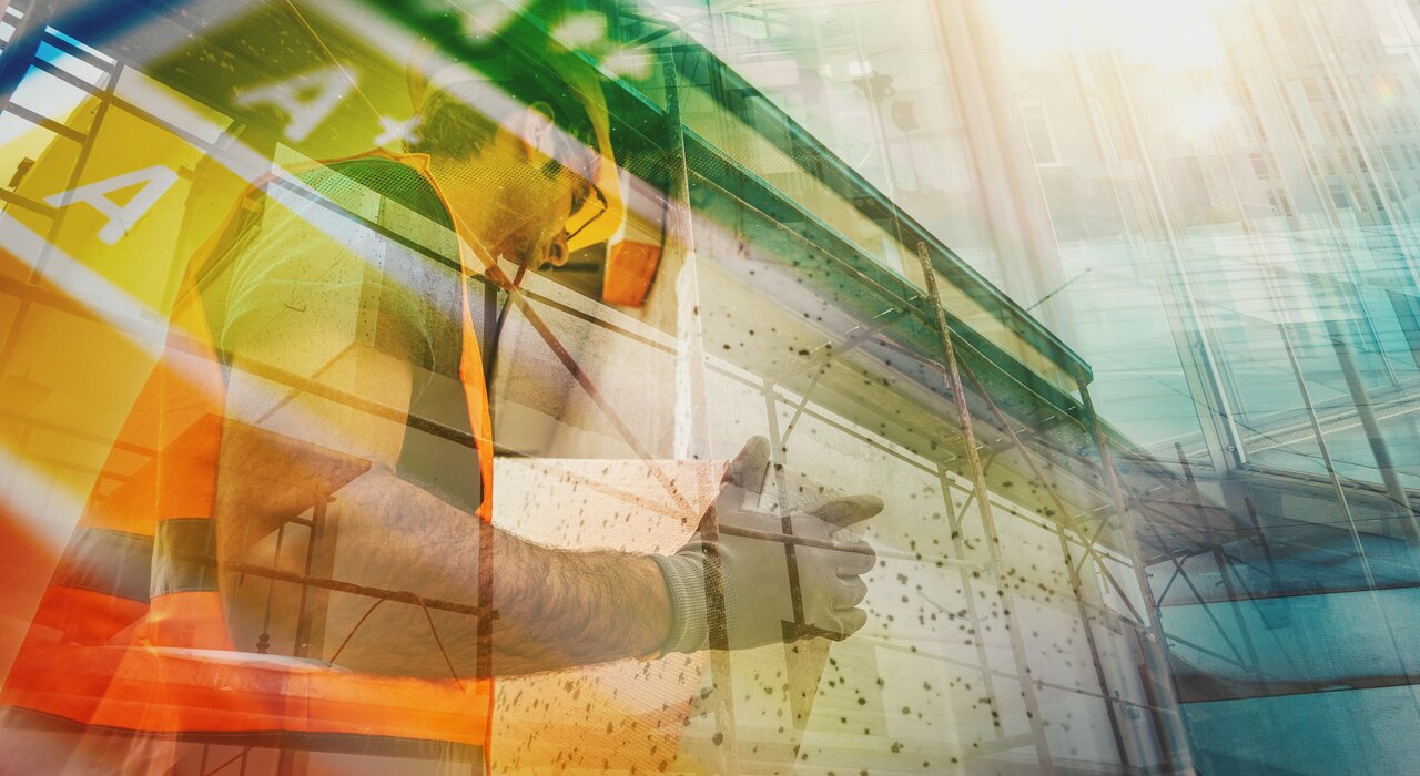 Artistic double exposure image showing a construction worker installing insulation boards on a building façade, overlaid with an energy efficiency rating scale. The visual highlights the role of external wall insulation—supplied by EWI Store—in improving building energy performance and reducing heat loss.