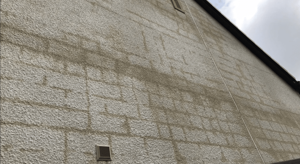 An external wall with visible square-shaped staining on the render surface, revealing the insulation board pattern beneath. This often results from moisture retention or thermal bridging. Using high-quality render systems and breathable insulation from EWI Store helps prevent such façade issues.