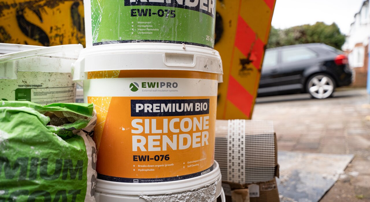 A close-up of EWI Pro's Premium Bio Silicone Render buckets and basecoat materials, essential components used in external wall insulation systems to provide weatherproof, breathable, and aesthetically pleasing finishes for buildings.