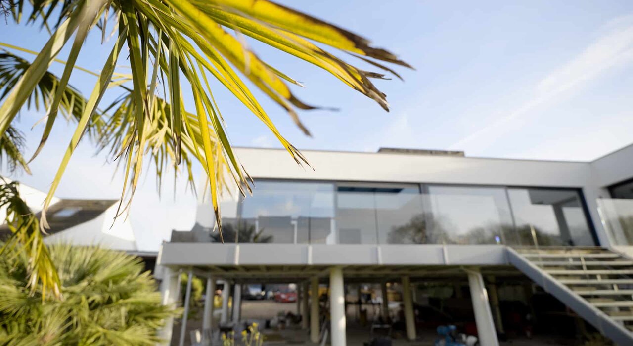 A modern house with large glazing and sharp lines, possibly in a warm climate, highlights the need for effective insulation and solar control to manage heat gain.