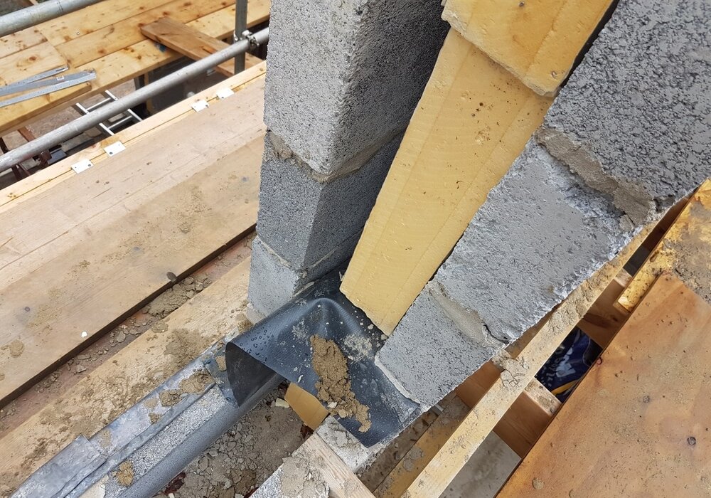 This is a close-up of a wall cavity with insulation being installed. You can also see a cavity tray at the base, which prevents water from entering the inner leaf of the wall.