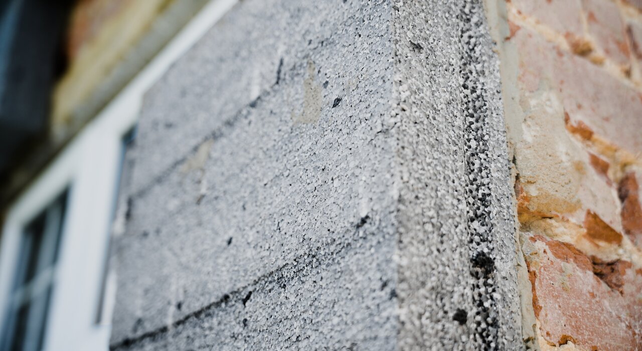Close-up of EPS (expanded polystyrene) boards applied to a brick wall.  This image shows EPS boards fixed to an external wall. EPS is a common material used in external wall insulation due to its excellent thermal properties and lightweight nature.