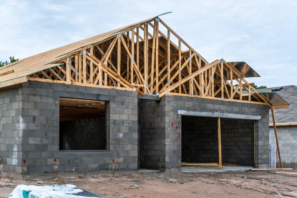 A partially built block home with timber roof framing. Installing external wall insulation on the masonry can significantly improve thermal comfort.