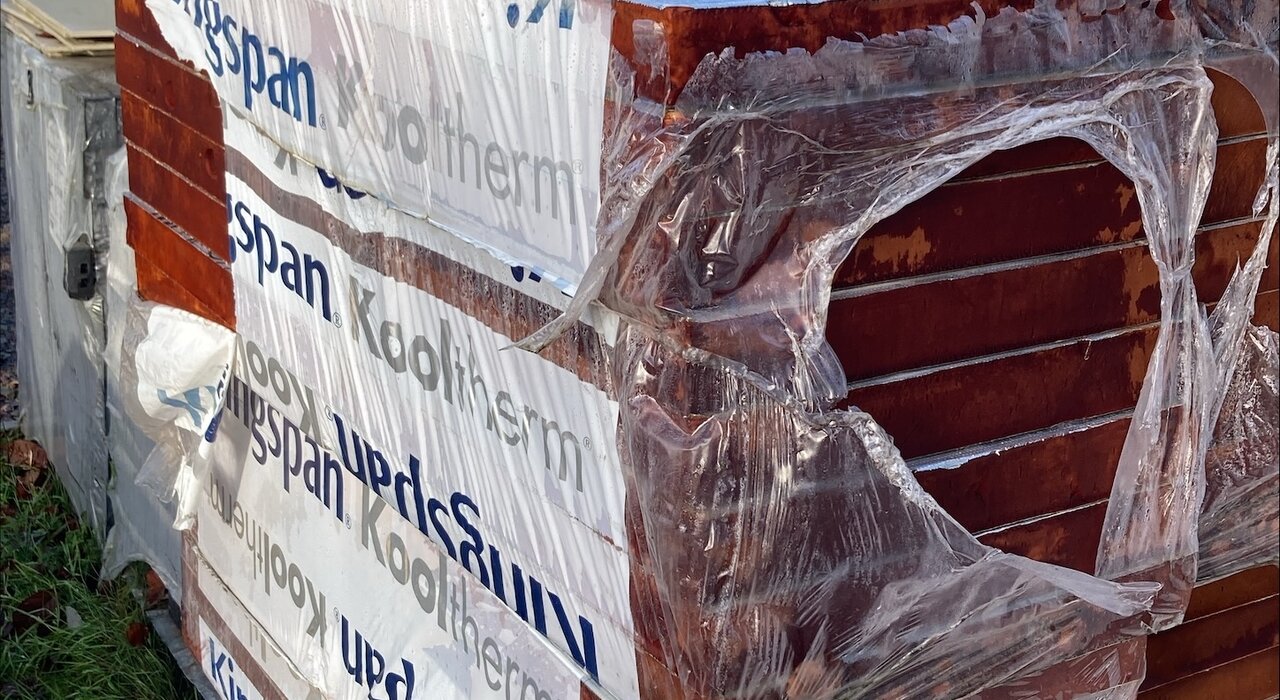 Pallets of Kingspan Kooltherm phenolic insulation, with visible moisture damage and broken packaging. This highlights the importance of proper on-site storage for insulation boards to maintain performance. EWI Store recommends dry, protected storage for all insulation products.