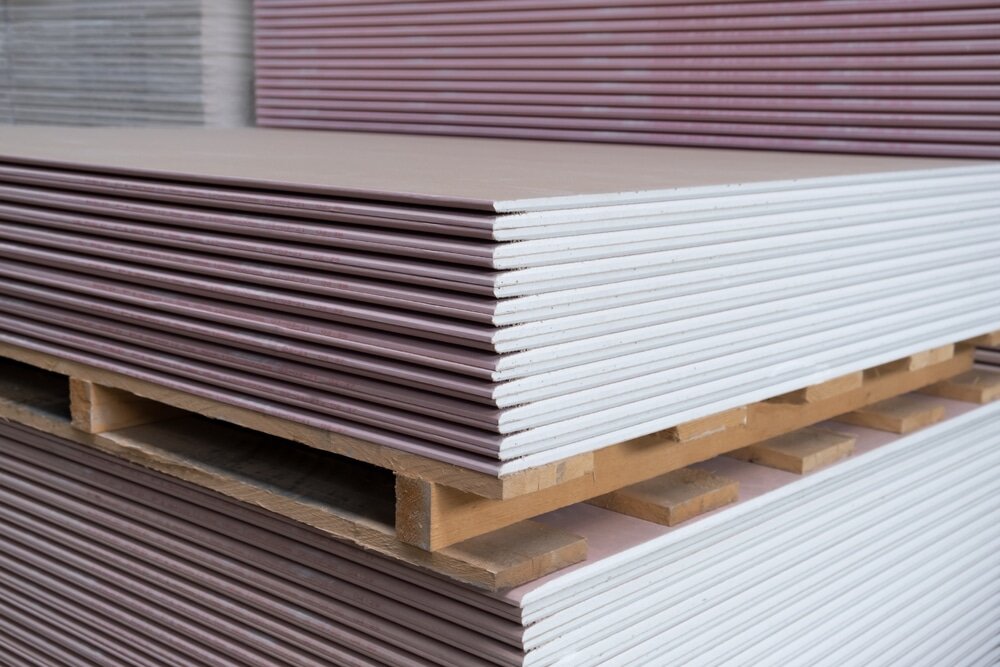 Neatly stacked plasterboards with pink cores—indicating fire-resistant (Type F) gypsum boards—ready for use in internal partitions or ceilings. These are especially suited for areas where fire protection is required and can complement internal insulation upgrades alongside EWI systems.