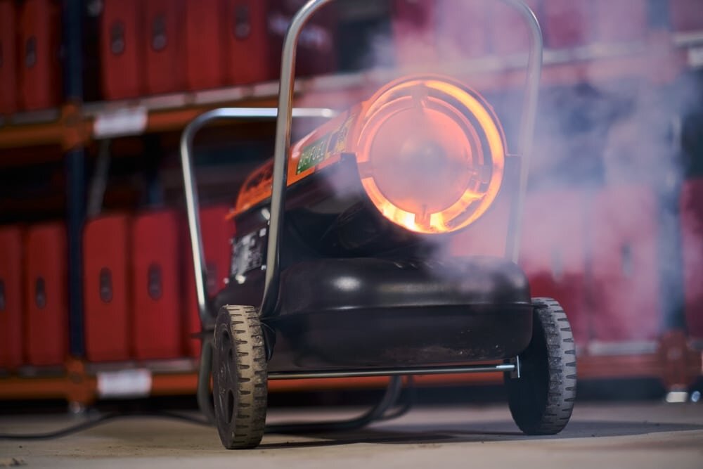 Close-up of a portable industrial heater in operation on a construction site. These heaters provide essential warmth during colder months, helping to maintain proper curing temperatures for renders and adhesives. Available from EWI Store, site heaters ensure optimal performance and comfort on external wall insulation projects.