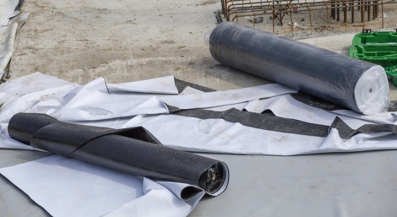 Rolls of damp-proof membrane or geotextile laid out on a construction site. These materials provide essential protection against moisture and are commonly used beneath flooring or foundations. EWI Store offers a range of waterproofing membranes for various insulation and groundworks applications.