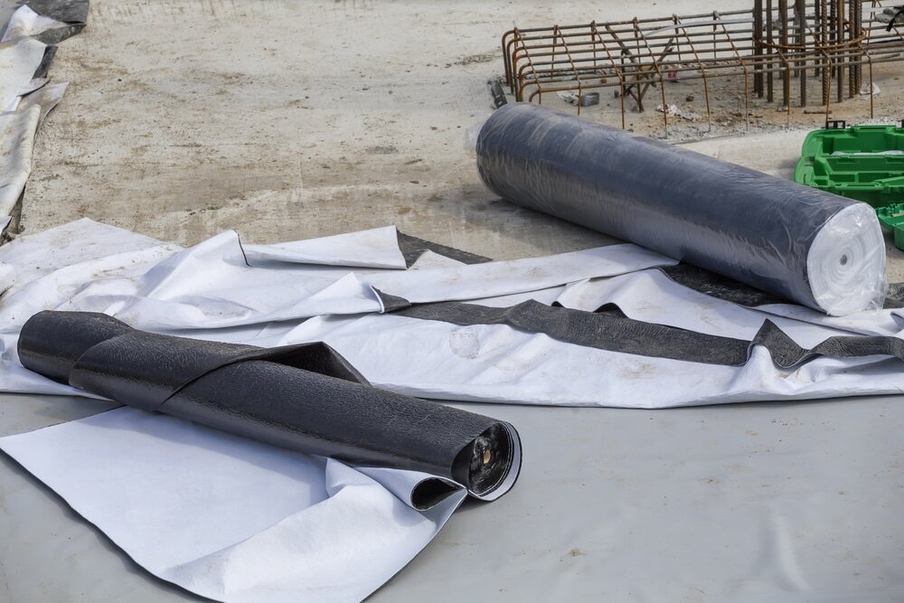 Rolls of damp-proof membrane or geotextile laid out on a construction site. These materials provide essential protection against moisture and are commonly used beneath flooring or foundations. EWI Store offers a range of waterproofing membranes for various insulation and groundworks applications.
