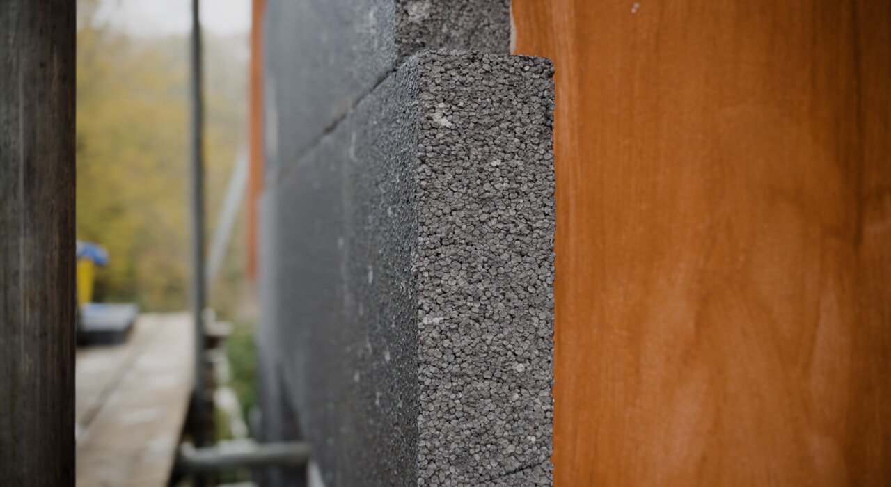 Close-up of a dark grey graphite-enhanced EPS insulation board installed on an external wall. This type of insulation offers improved thermal performance due to the addition of graphite particles. Graphite EPS is a popular choice for EWI systems and is available from EWI Store.