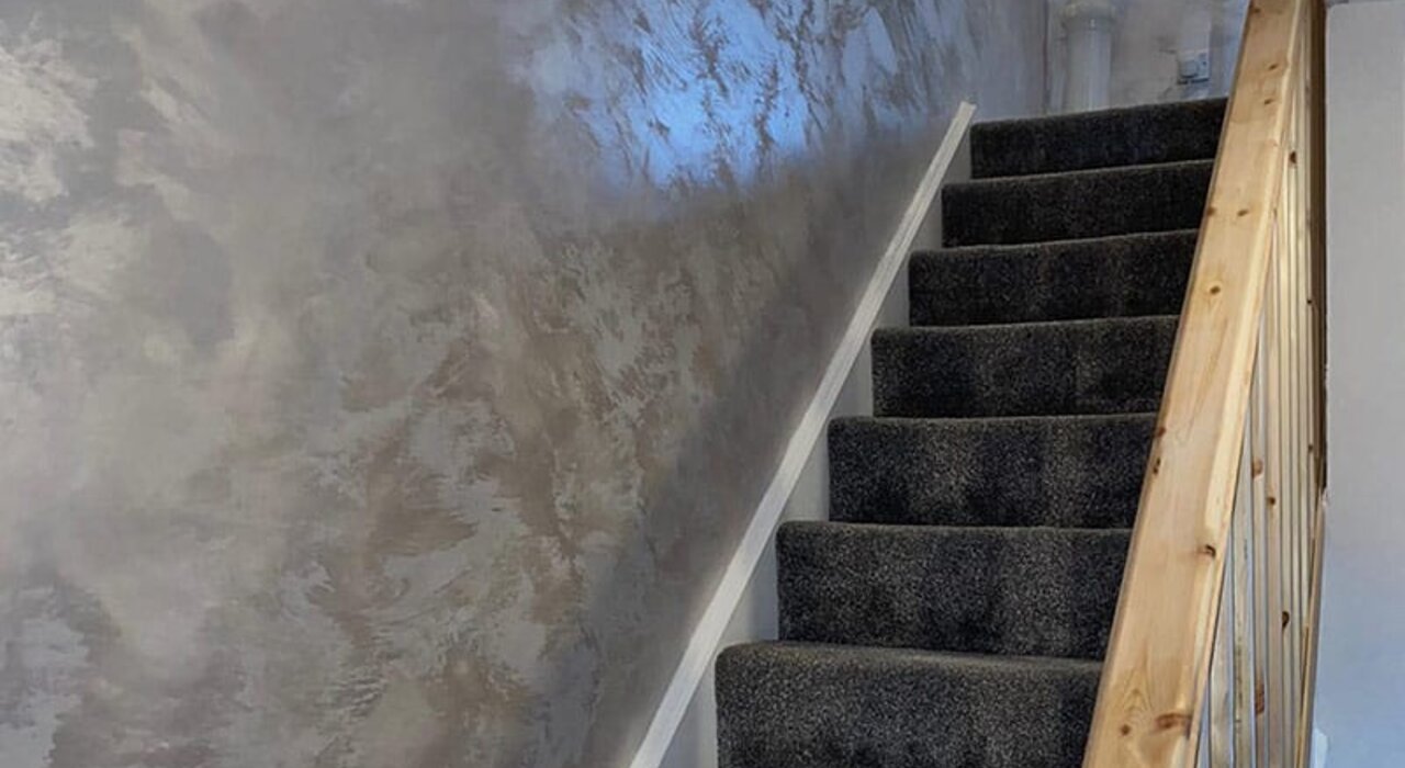 Close-up of a feature wall finished with polished plaster in a metallic bronze tone. The smooth, reflective surface adds a luxury finish ideal for interior spaces. Decorative plaster systems available from EWI Store offer custom texture and sheen.