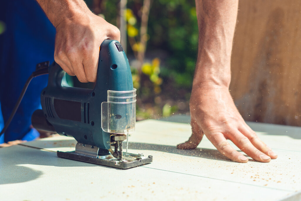 Jigsaw cutting through an insulation or cement board during on-site installation. Precision cutting is key when fitting boards around openings and corners as part of EWI installations.