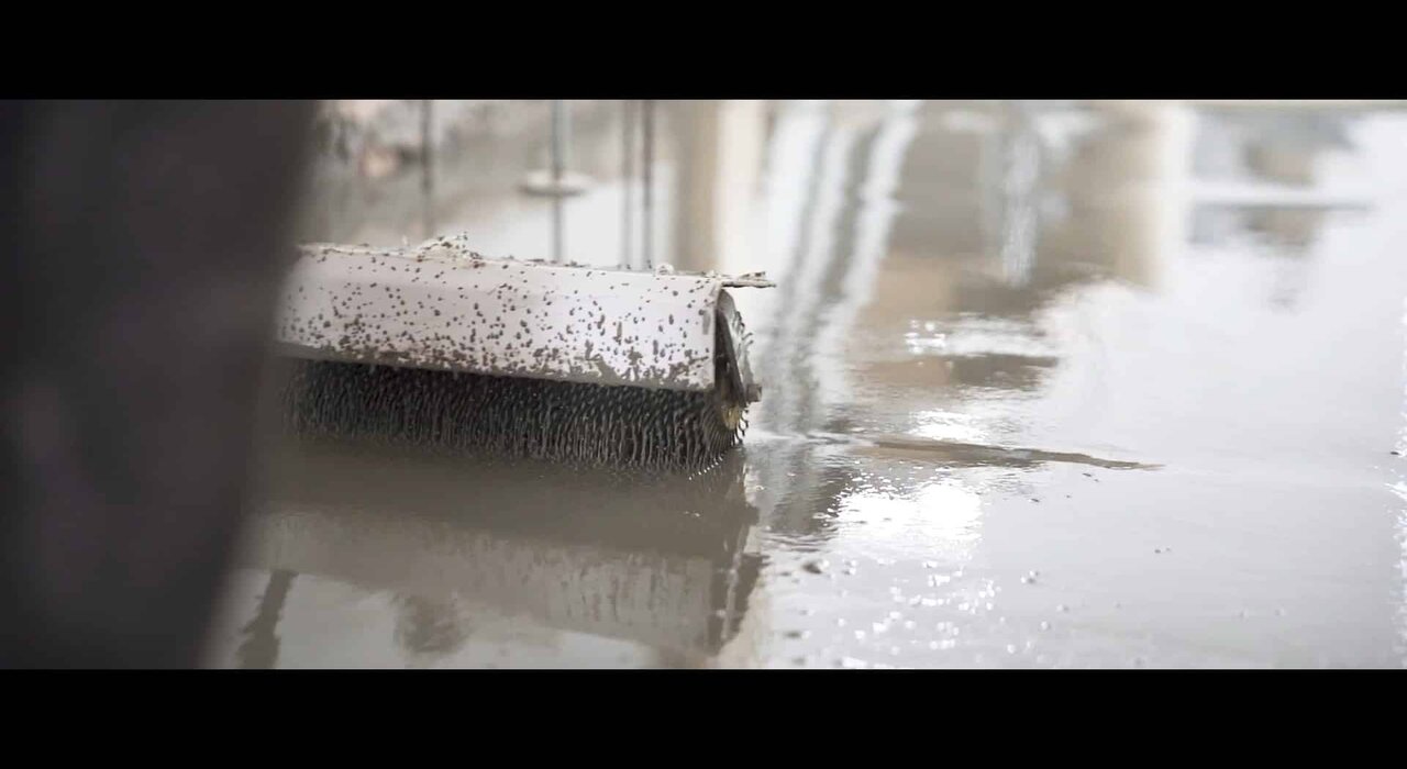 Close-up of a spiked roller being used on freshly poured self-levelling compound. Available through EWI Store, our surface preparation tools ensure a smooth, air-free screed layer for optimal substrate performance.