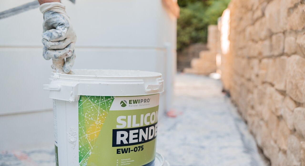 Tub of EWI Pro Silicone Render (EWI-075) being mixed for application on a façade. This breathable, flexible topcoat render is ideal for modern homes and retrofit projects, available in a wide range of colours at EWI Store.