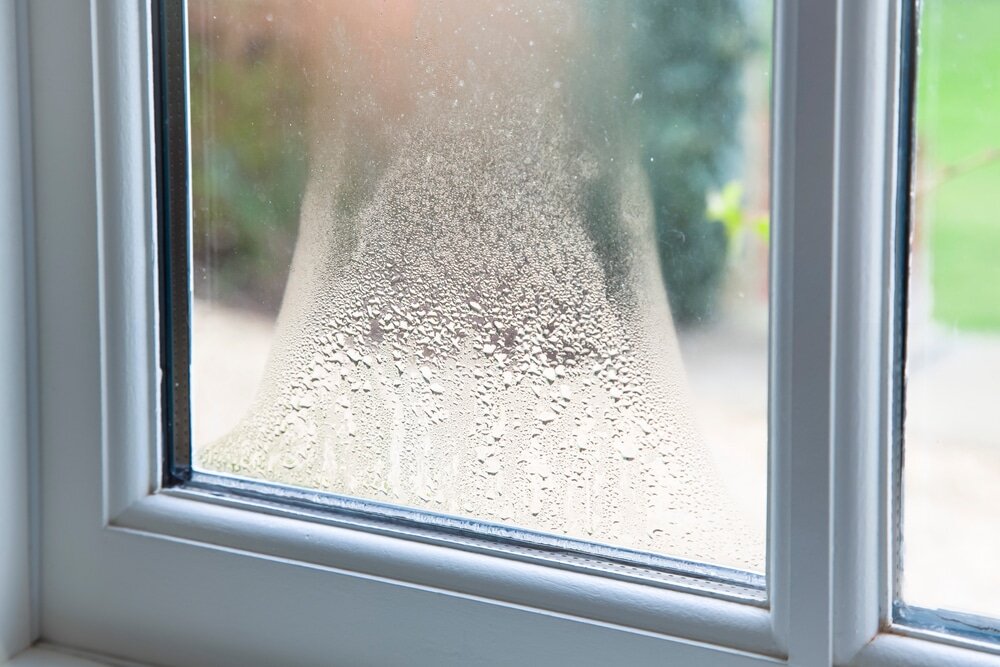 Close-up of condensation forming on the inside of a double-glazed window. This moisture issue is often caused by inadequate ventilation or insulation. EWI Store’s breathable renders and insulation systems help reduce condensation risk in homes.