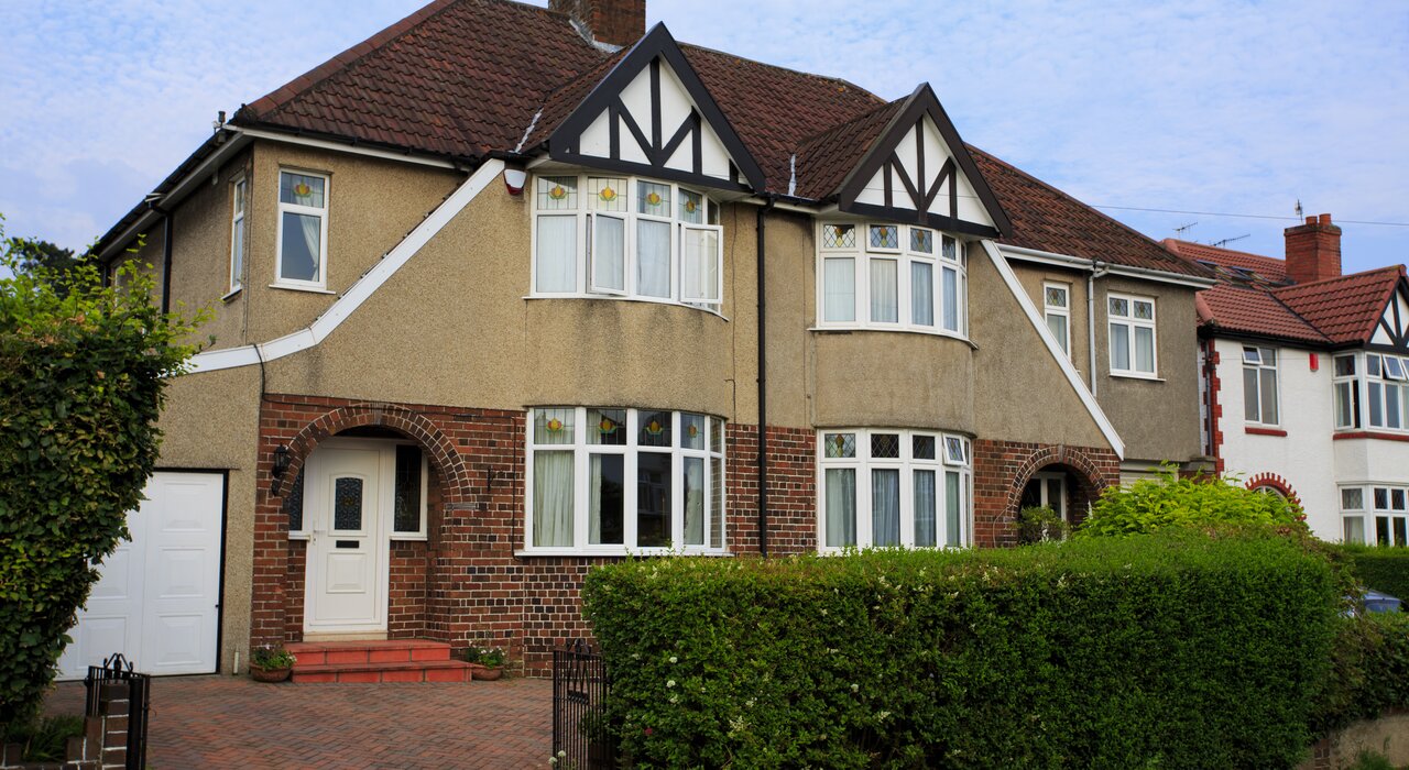 Street view of a traditional UK semi-detached house with pebble dash render and brickwork. EWI Store offers a full range of products to upgrade older homes with modern insulation systems, enhancing thermal performance while preserving exterior aesthetics.