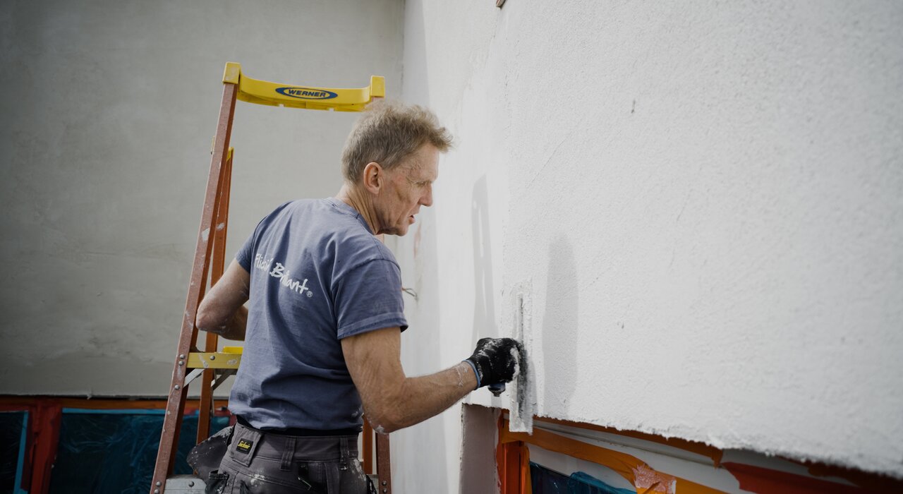 Application of Silicone Render in progress using a stainless steel trowel for a smooth, even finish. Available from EWI Store, our EWI Pro Silicone Renders provide a highly breathable, hydrophobic and flexible topcoat, perfect for achieving a long-lasting and low-maintenance façade in a range of textures and colours.