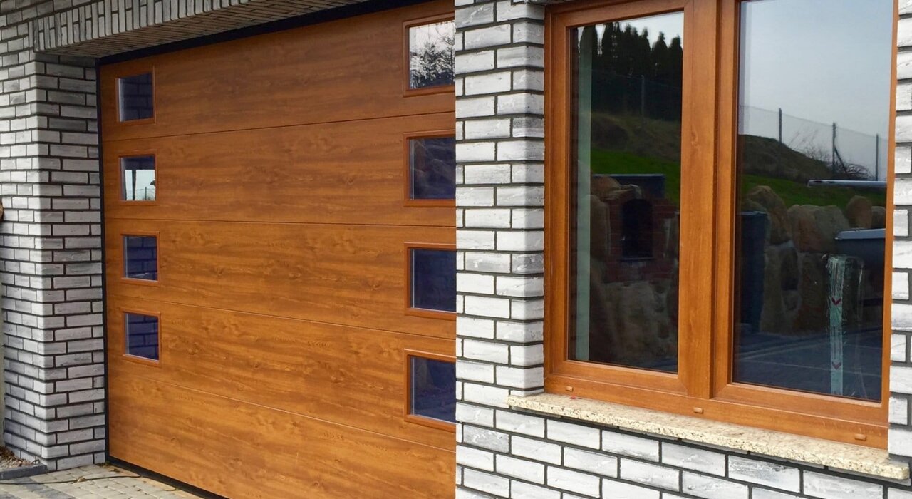 Contemporary garage with timber-effect door set within a facade of modern facing brick. EWI Store provides a wide selection of insulation and finishing solutions suitable for integrating traditional and modern design elements.