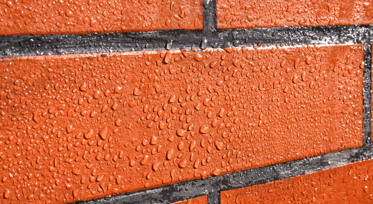 Water-repellent brickwork demonstrating effective hydrophobic protection. Use facade protection products like EWI-060 Water Repellent from EWI Store to prevent water ingress and maintain the aesthetic and structural integrity of your walls.