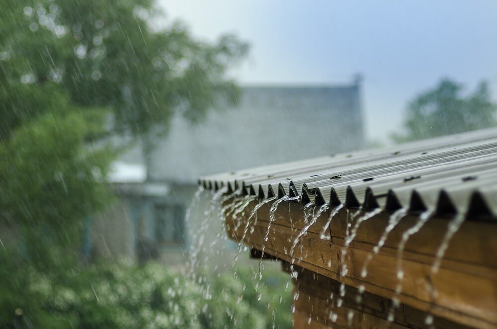 Rainwater running off a corrugated roof during a storm, highlighting the importance of effective weatherproofing. EWI Store supplies breathable yet waterproof render systems designed to shield homes from harsh UK weather while maintaining optimal moisture balance in the wall structure.