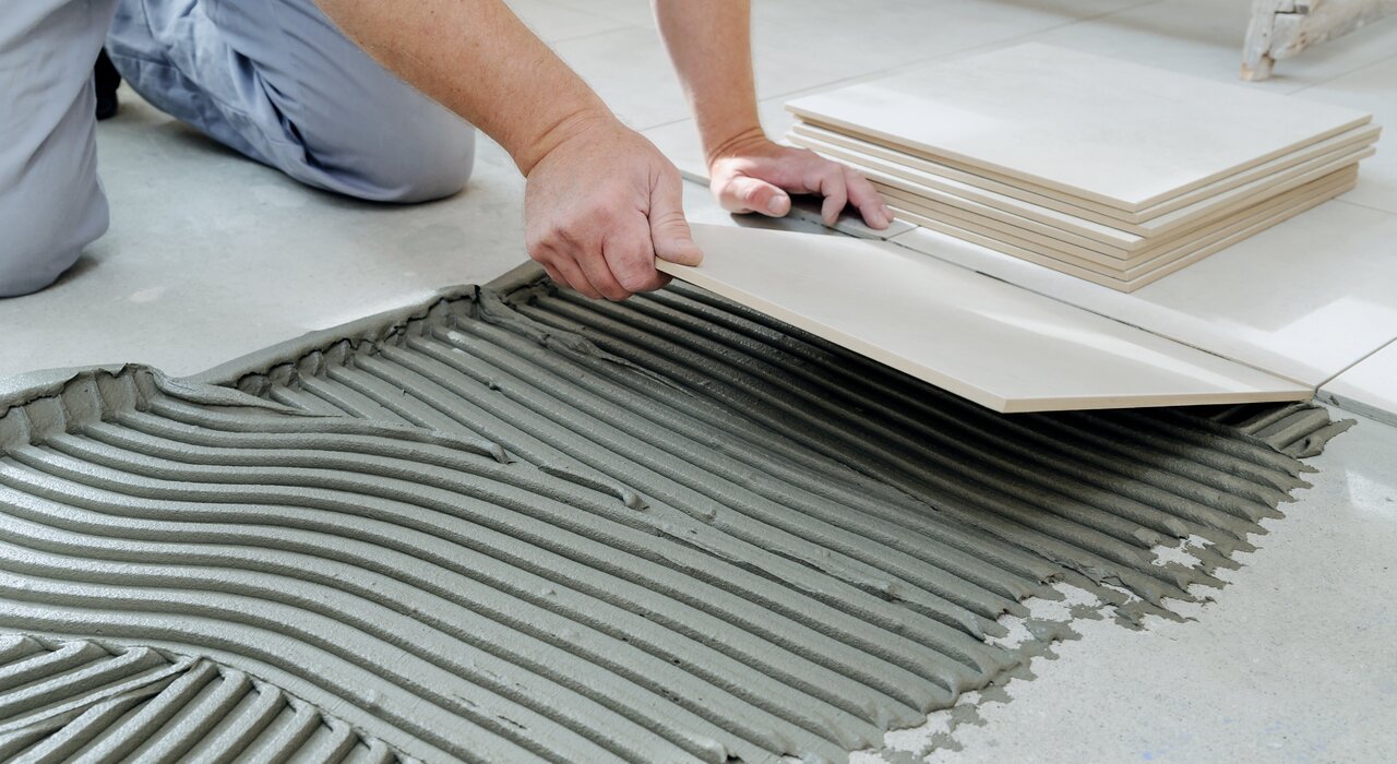 Application of tile adhesive in thick ribs on a floor prior to tile laying. EWI Store stocks high-performance tile adhesives suitable for both internal and external use, ensuring strong, flexible bonds with excellent workability and durability.