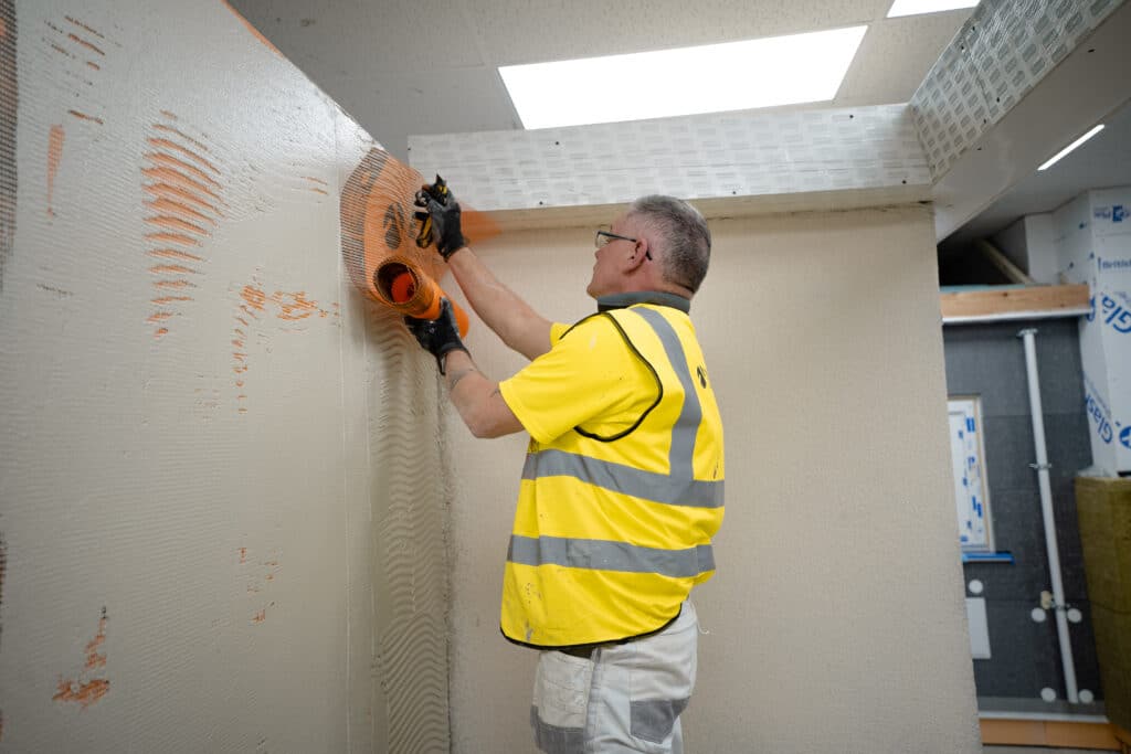 Paul from EWI Pro is seen here, installing Orange Fibreglass Mesh